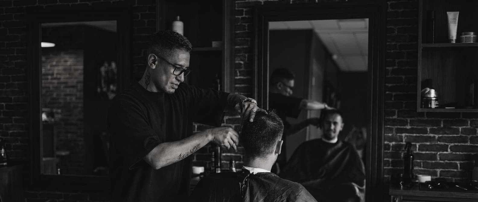 Marvin cutting a client’s hair at the mirror in the salon